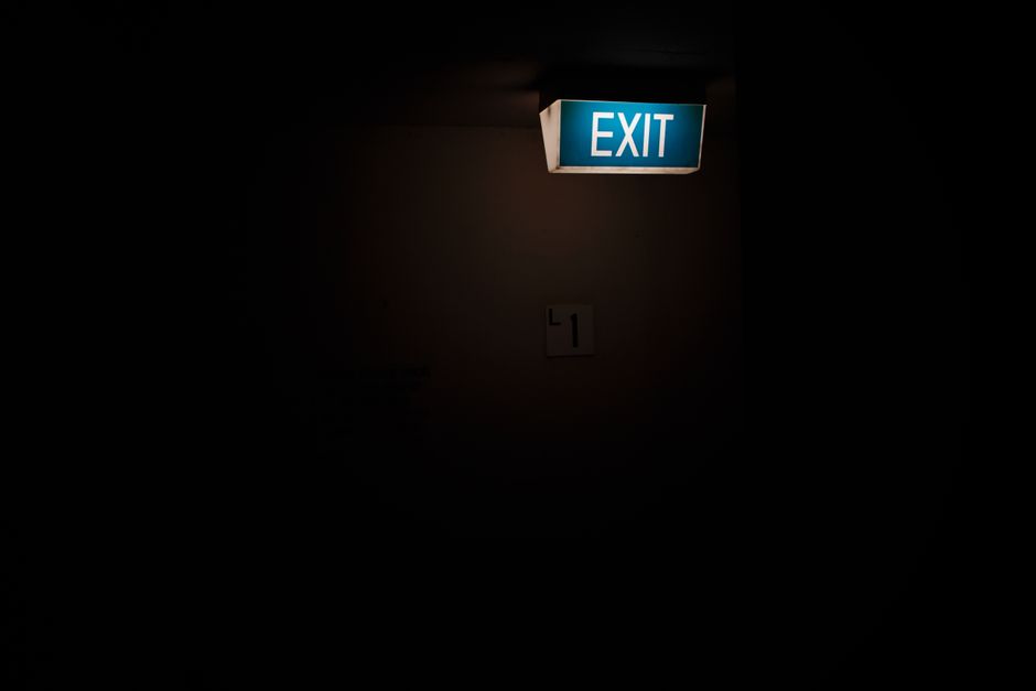 Illuminated hotel emergency exit sign glowing in a dark hallway